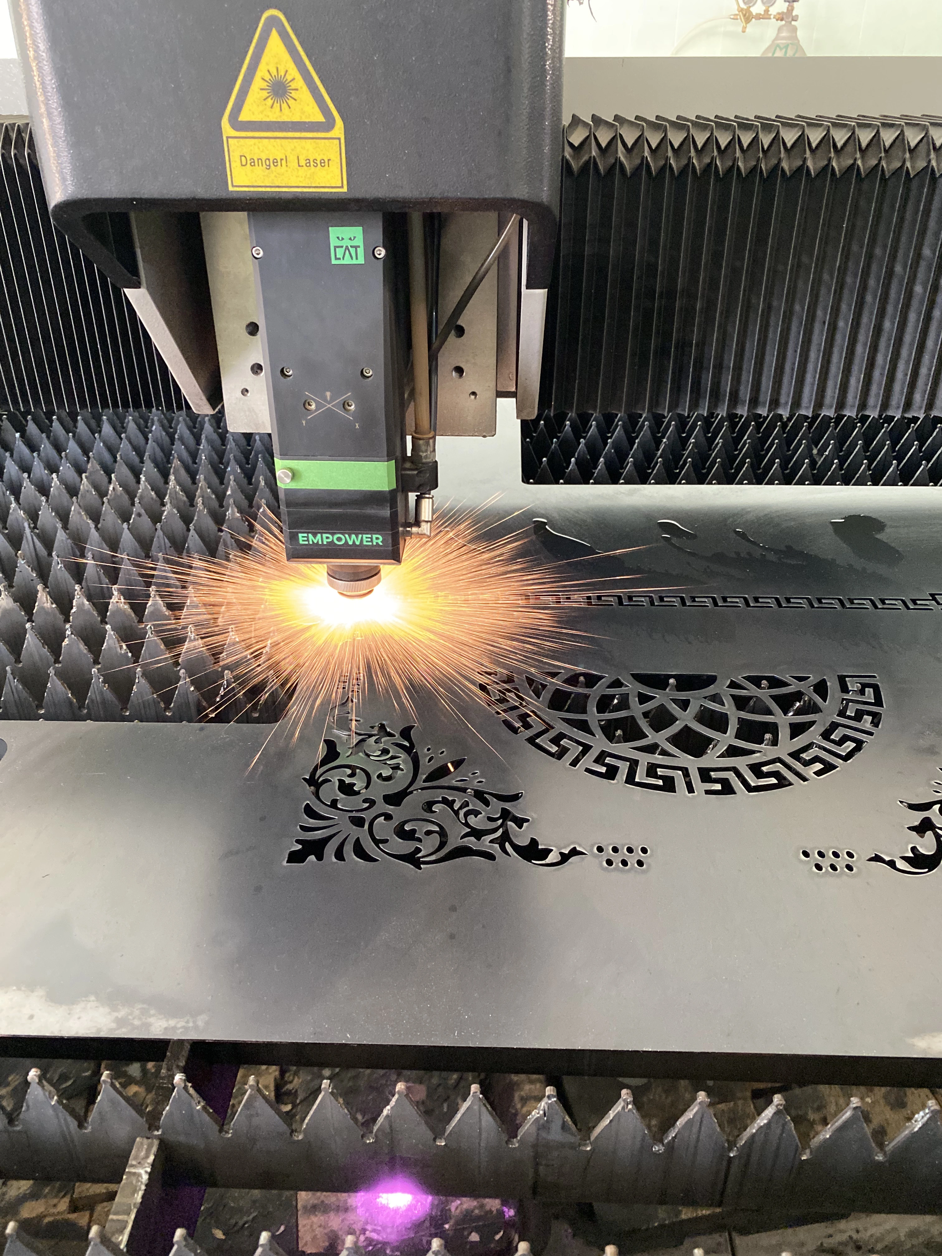 Proses fiber laser cutting pola display metal custom di Metalika Works